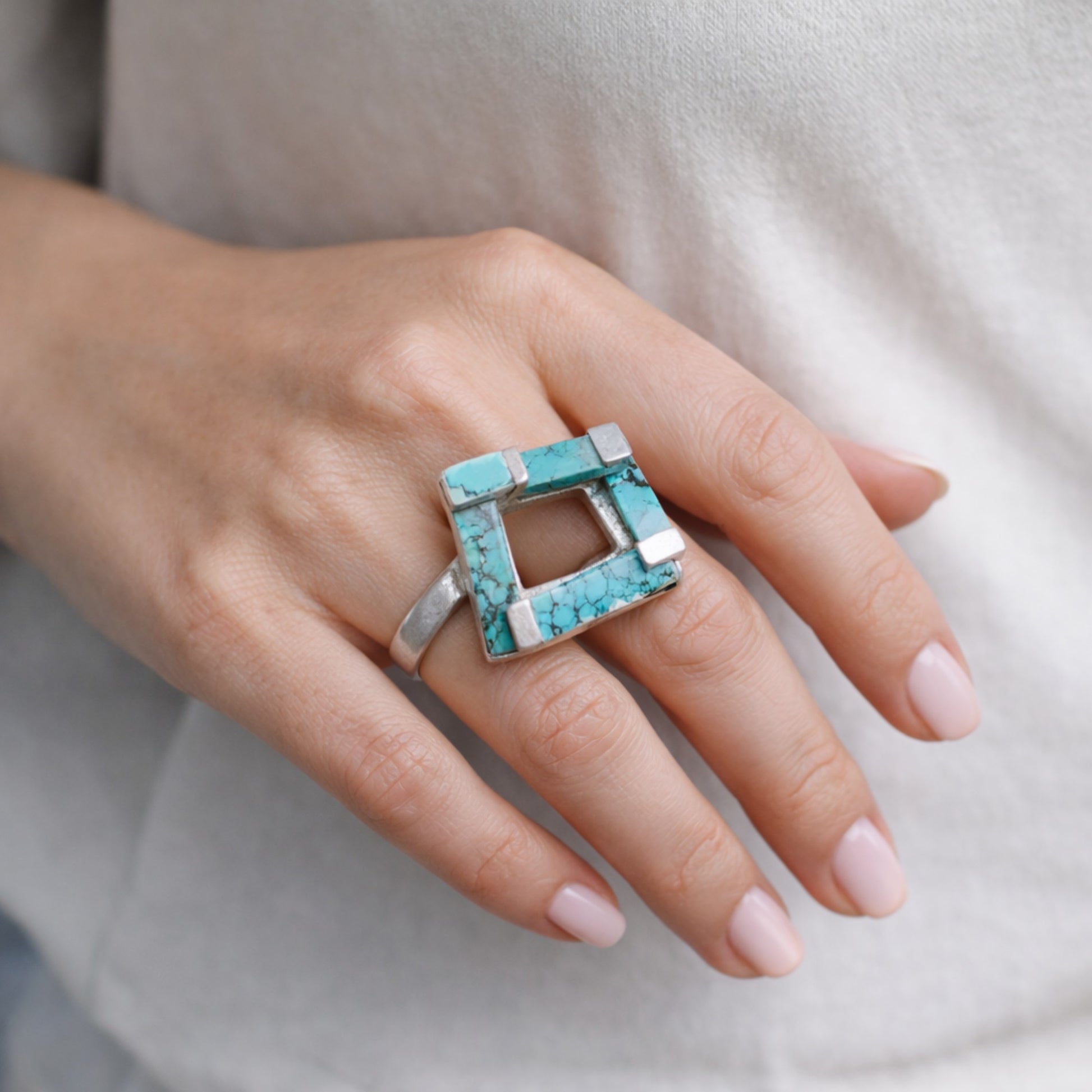 SILVER RING WITH TURQUOISE STONES IN A GEOMETRIC DESIGN