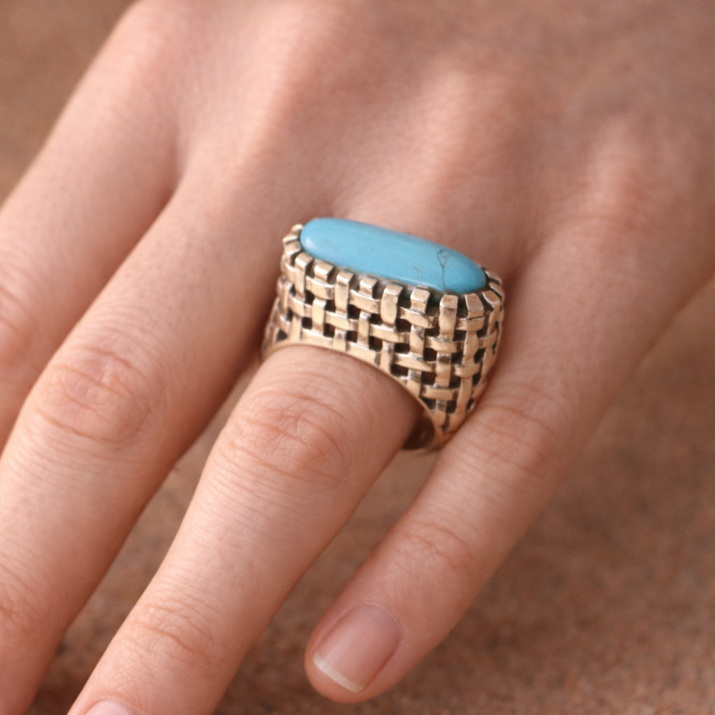 SILVER RING IN A WOVEN PATTERN FEATURING A TURQUOISE