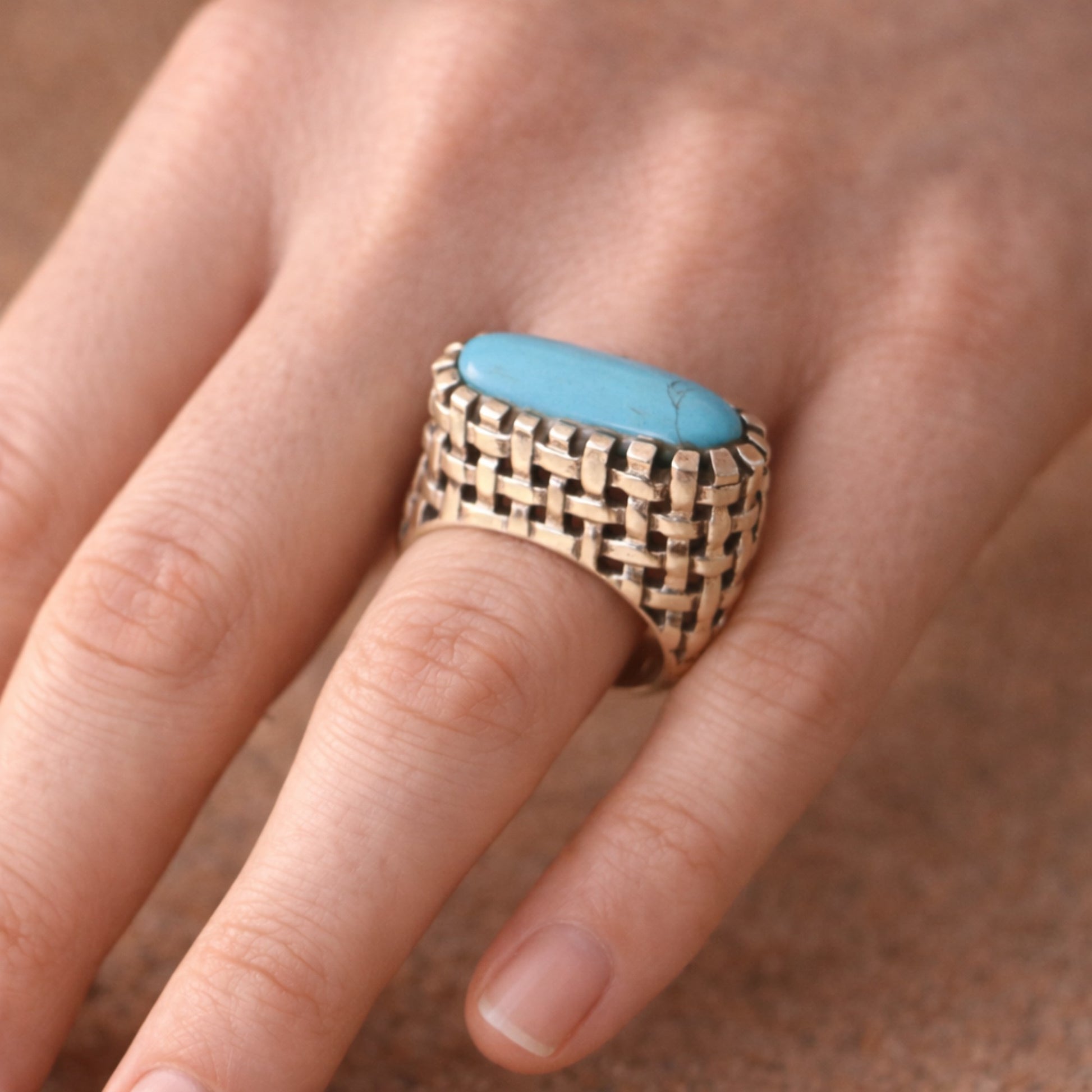 SILVER RING IN A WOVEN PATTERN FEATURING A TURQUOISE