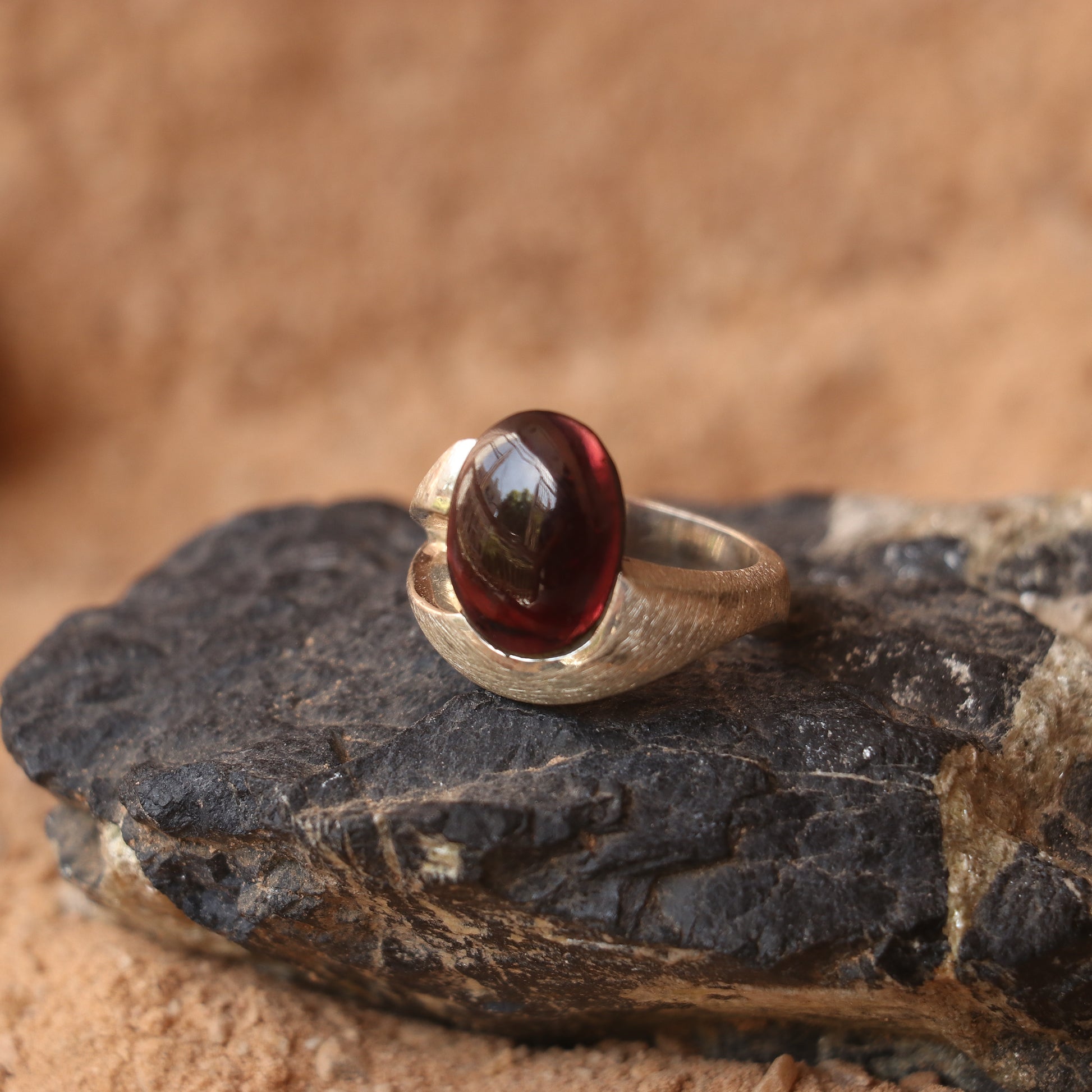 SILVER SMOOTH BAND FEATURING A GARNET