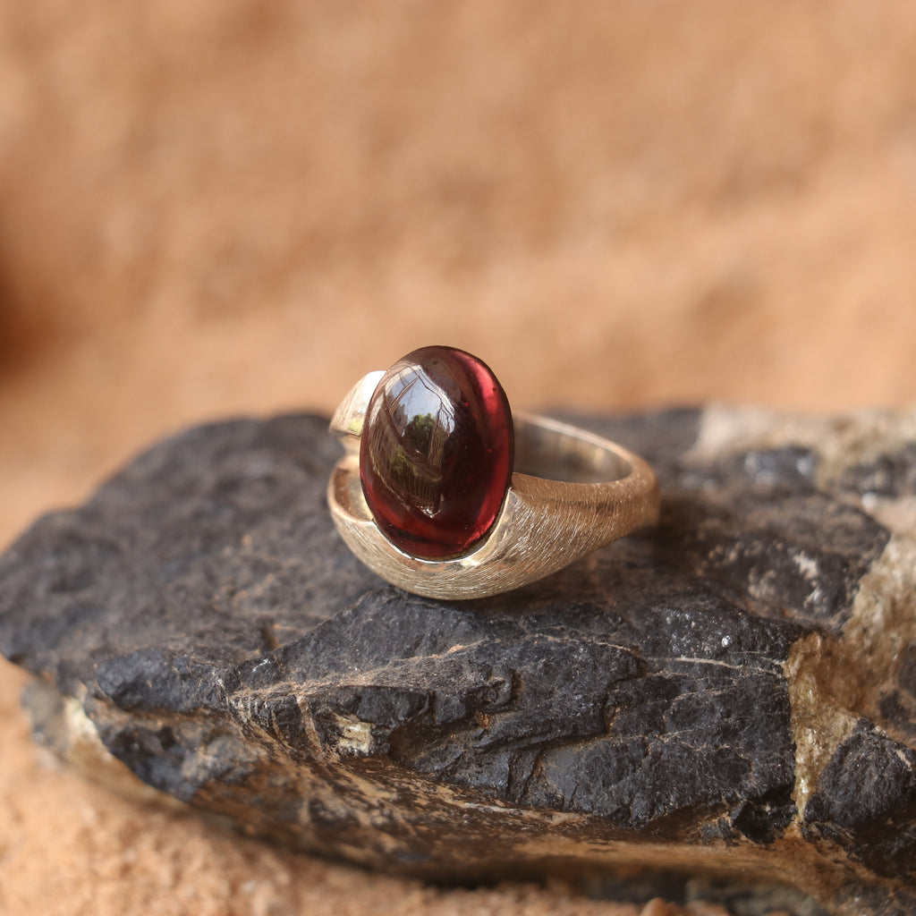SILVER SMOOTH BAND FEATURING A GARNET
