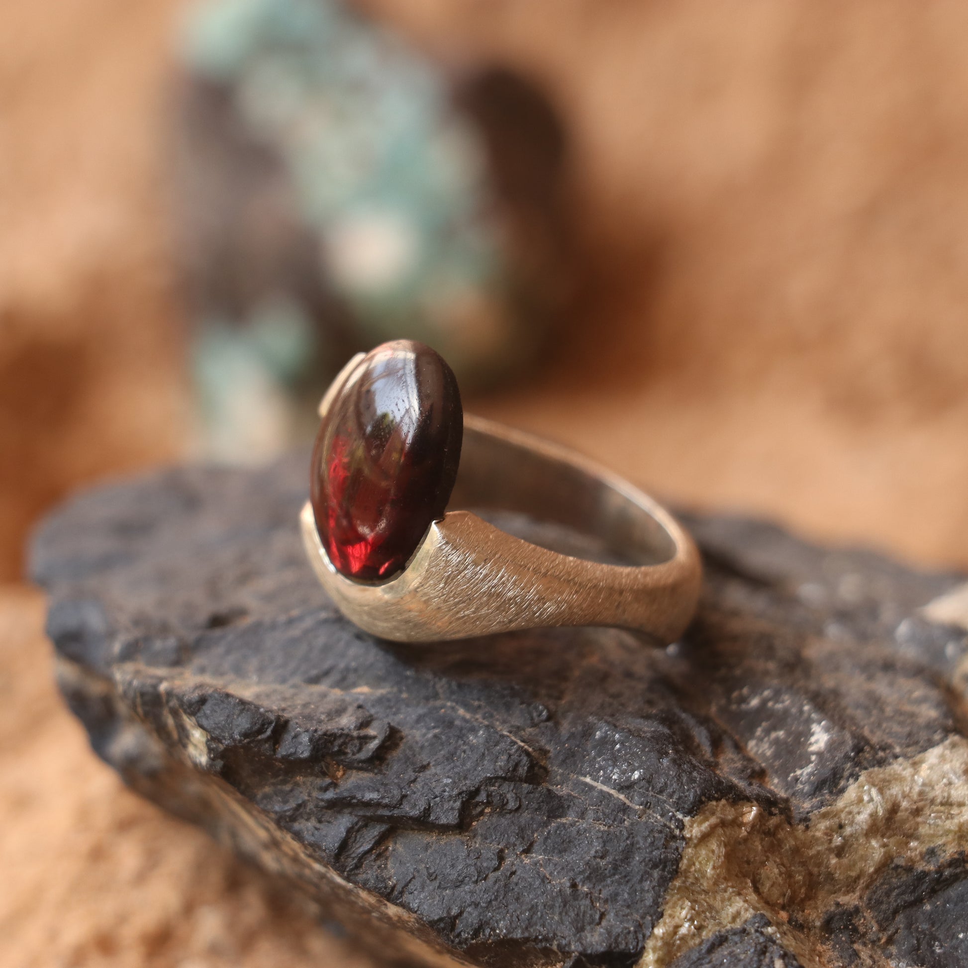 SILVER SMOOTH BAND FEATURING A GARNET