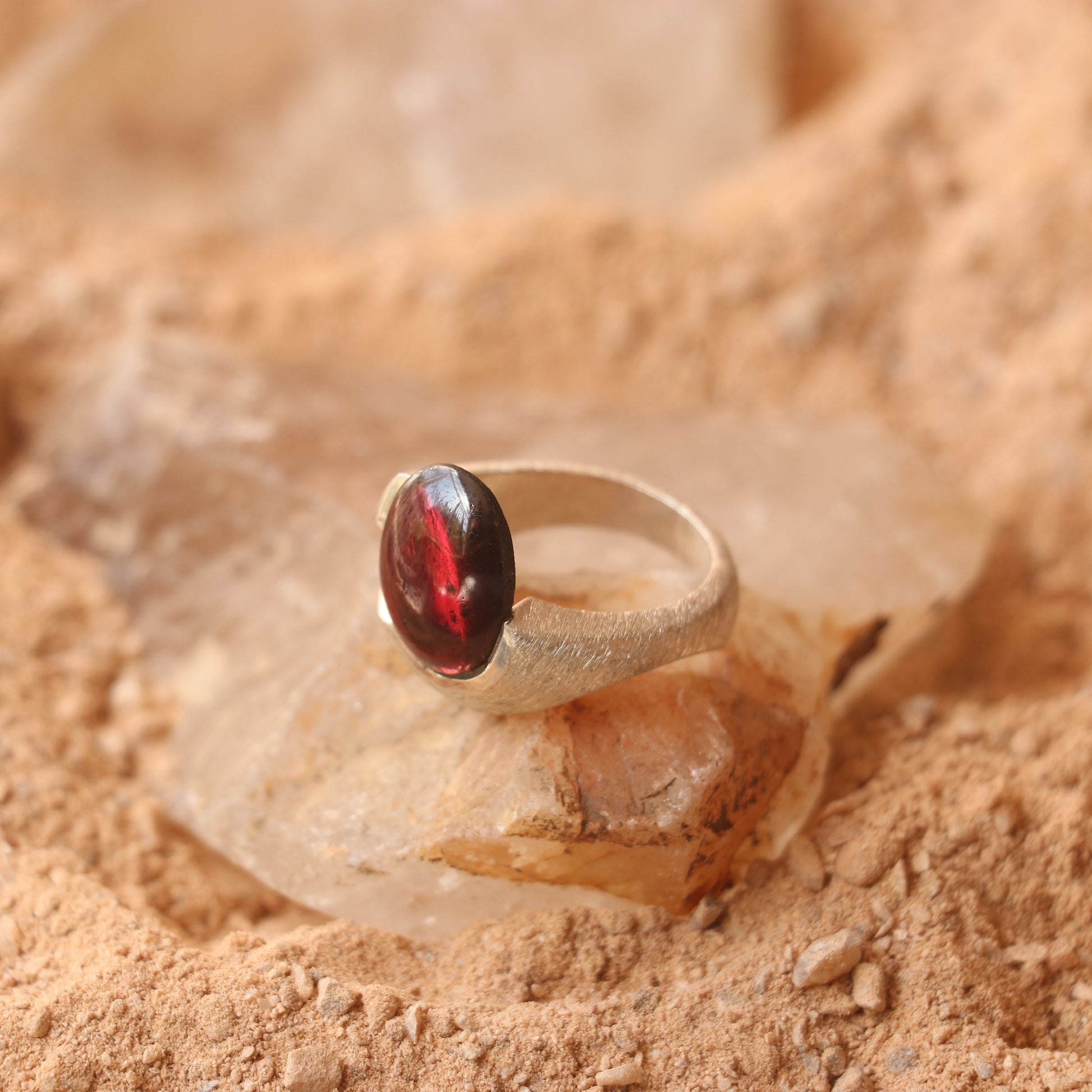 SILVER SMOOTH BAND FEATURING A GARNET