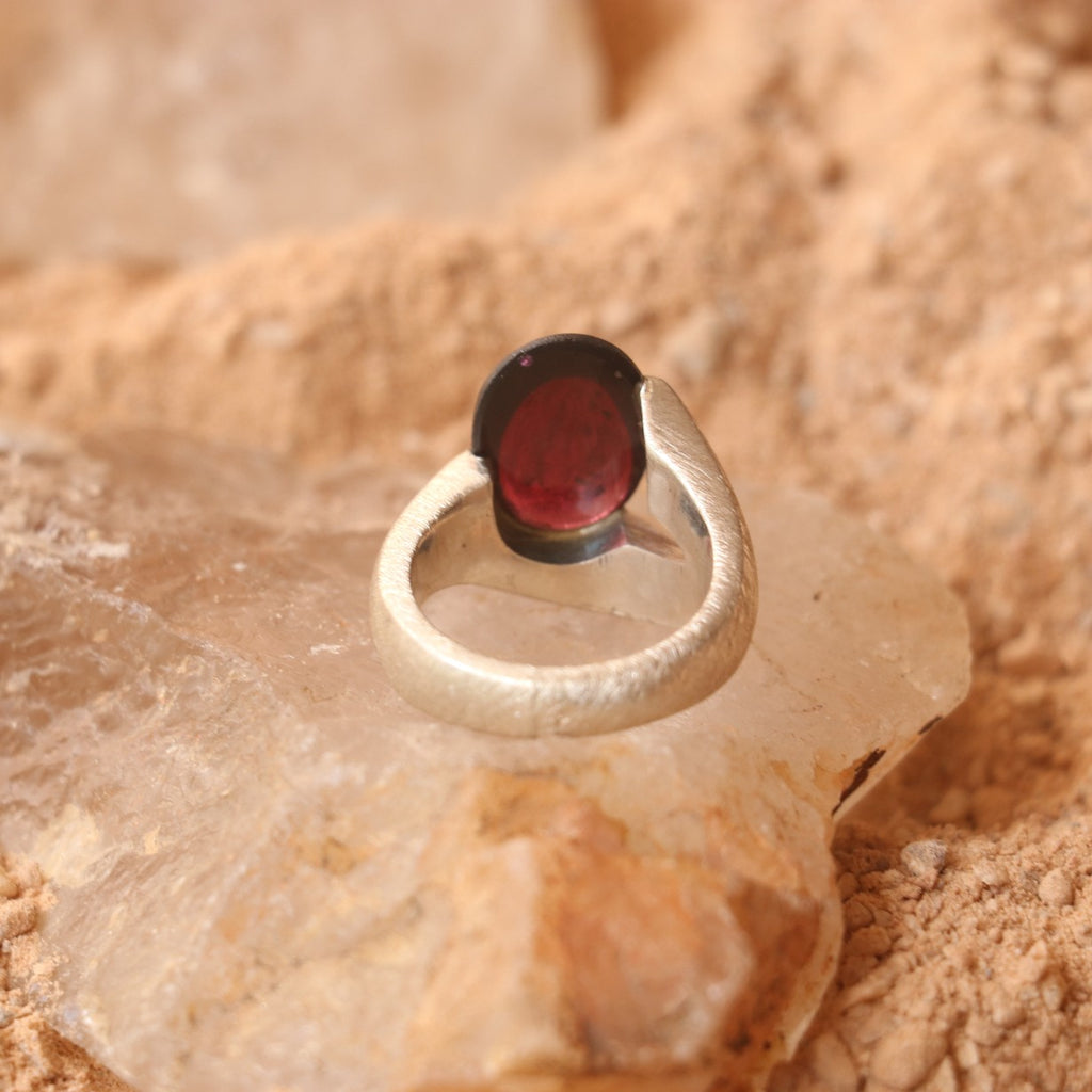 SILVER SMOOTH BAND FEATURING A GARNET
