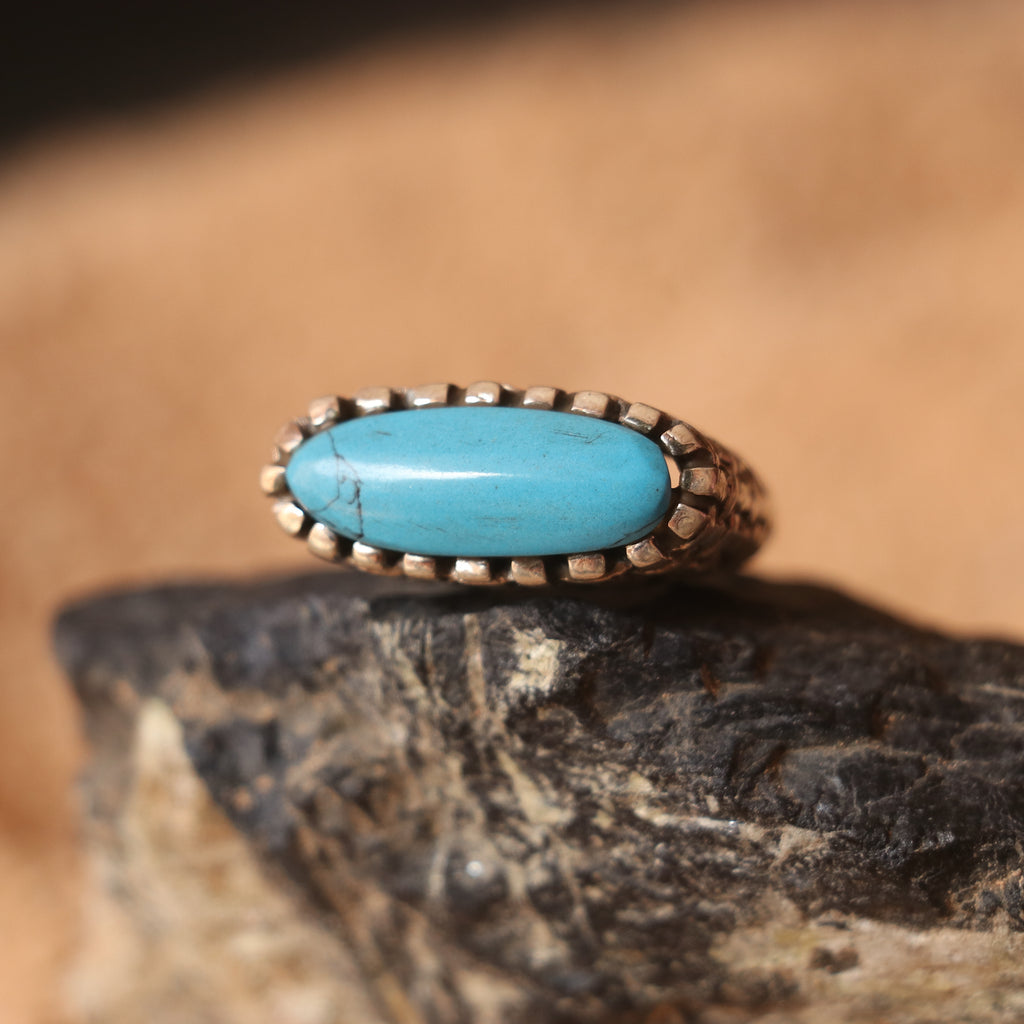 SILVER RING IN A WOVEN PATTERN FEATURING A TURQUOISE