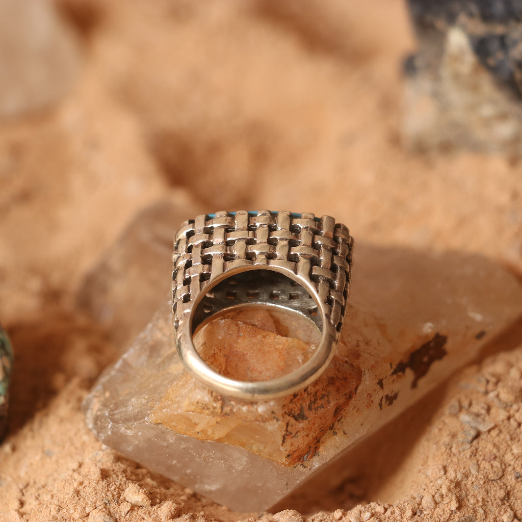 SILVER RING IN A WOVEN PATTERN FEATURING A TURQUOISE