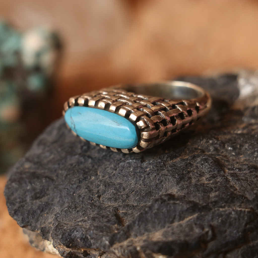 SILVER RING IN A WOVEN PATTERN FEATURING A TURQUOISE