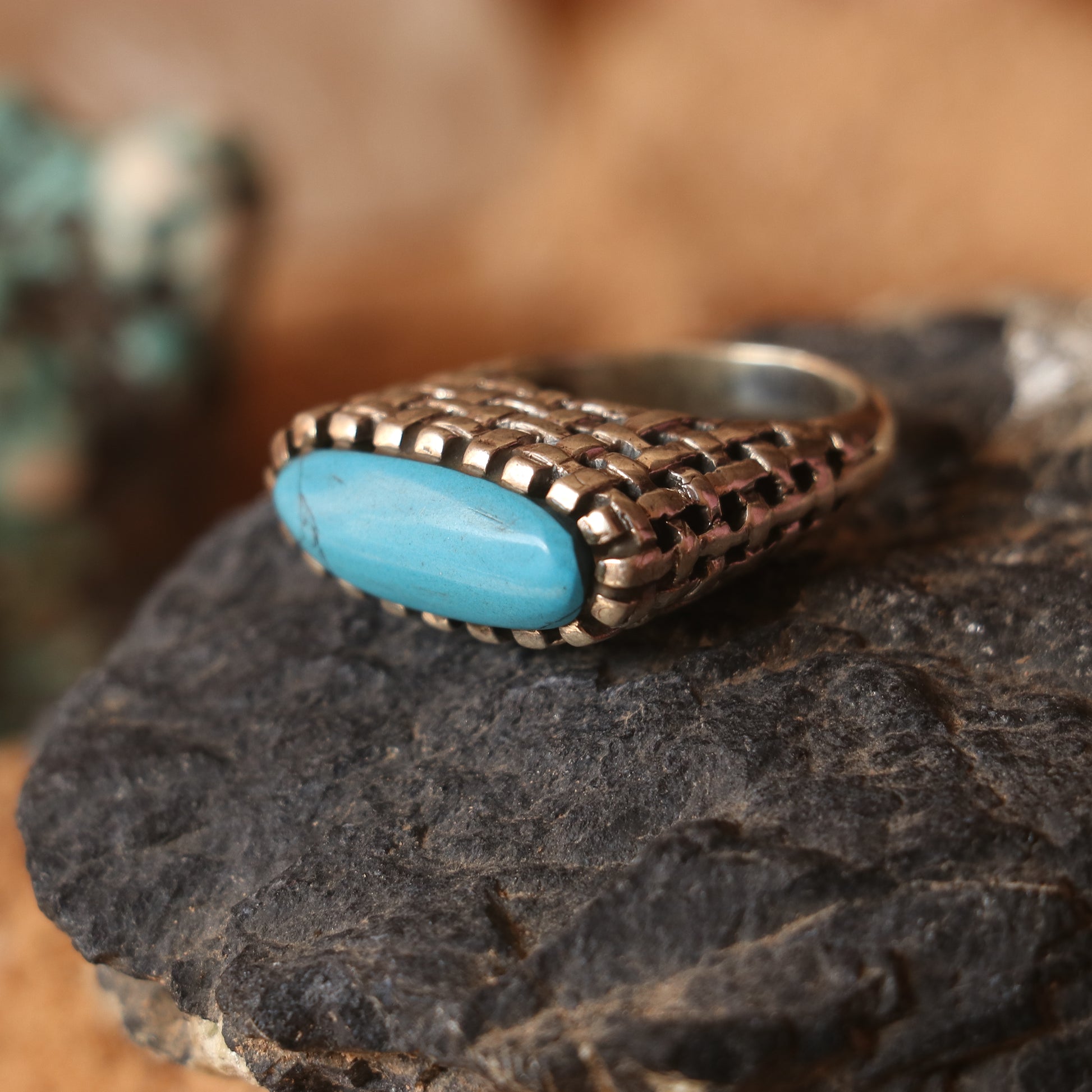 SILVER RING IN A WOVEN PATTERN FEATURING A TURQUOISE