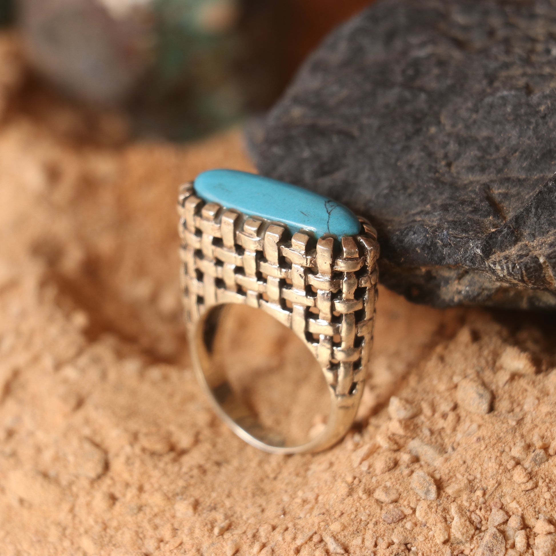 SILVER RING IN A WOVEN PATTERN FEATURING A TURQUOISE