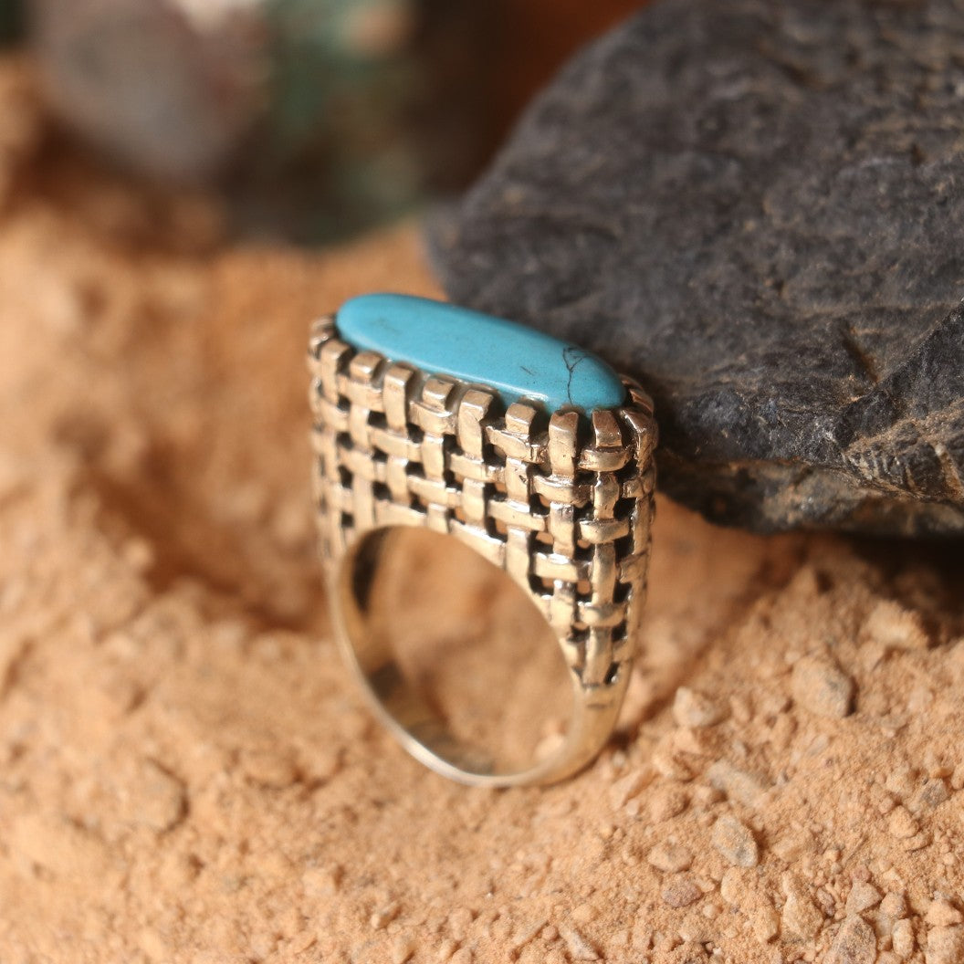 SILVER RING IN A WOVEN PATTERN FEATURING A TURQUOISE
