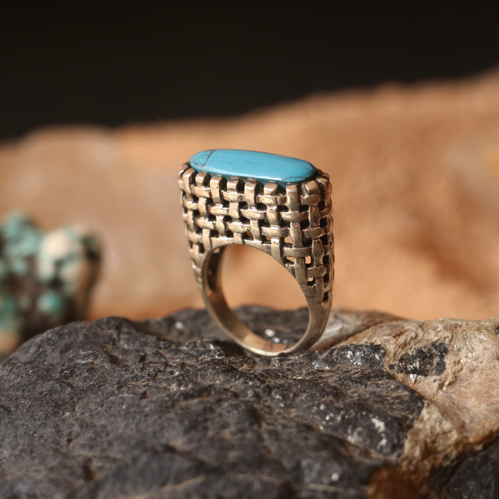 SILVER RING IN A WOVEN PATTERN FEATURING A TURQUOISE