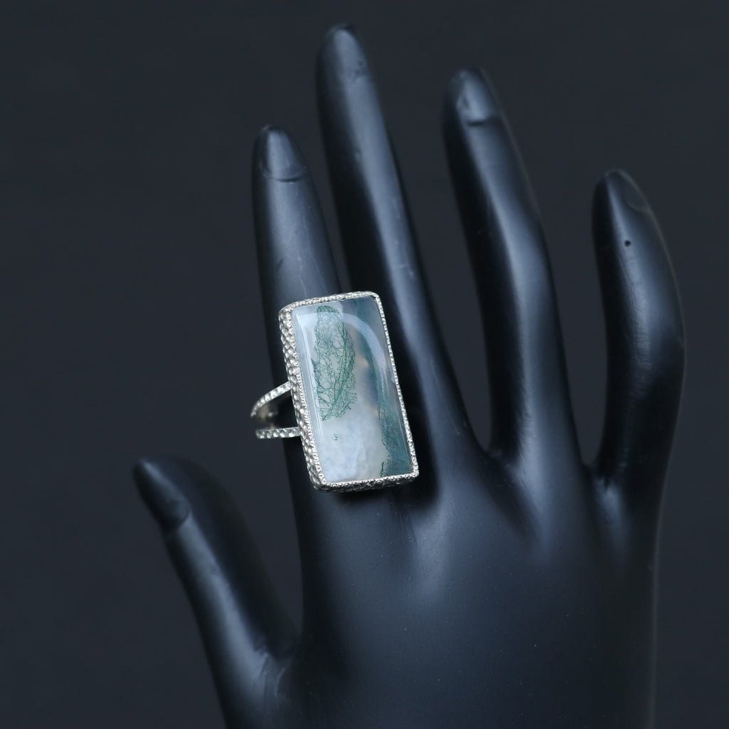 SILVER RING SHOWCASING A LARGE RECTANGULAR MOSS AGATE STONE