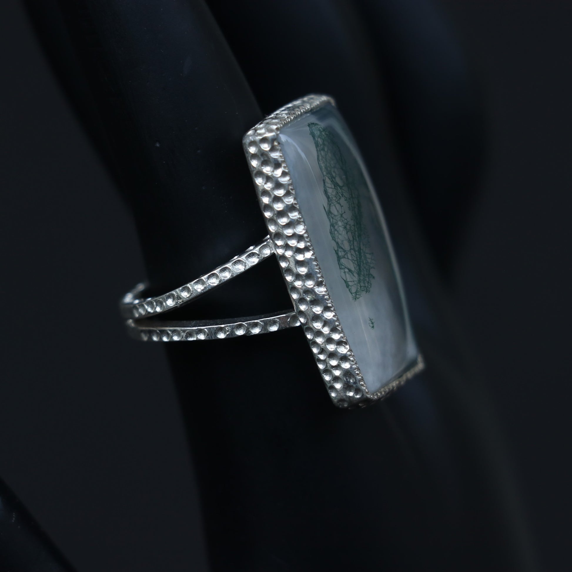 SILVER RING SHOWCASING A LARGE RECTANGULAR MOSS AGATE STONE