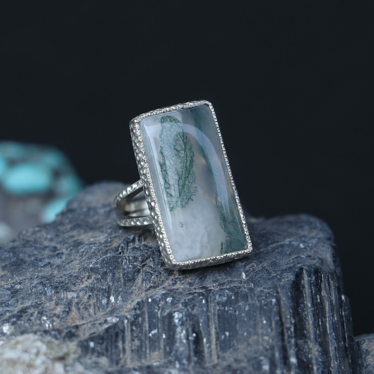 SILVER RING SHOWCASING A LARGE RECTANGULAR MOSS AGATE STONE