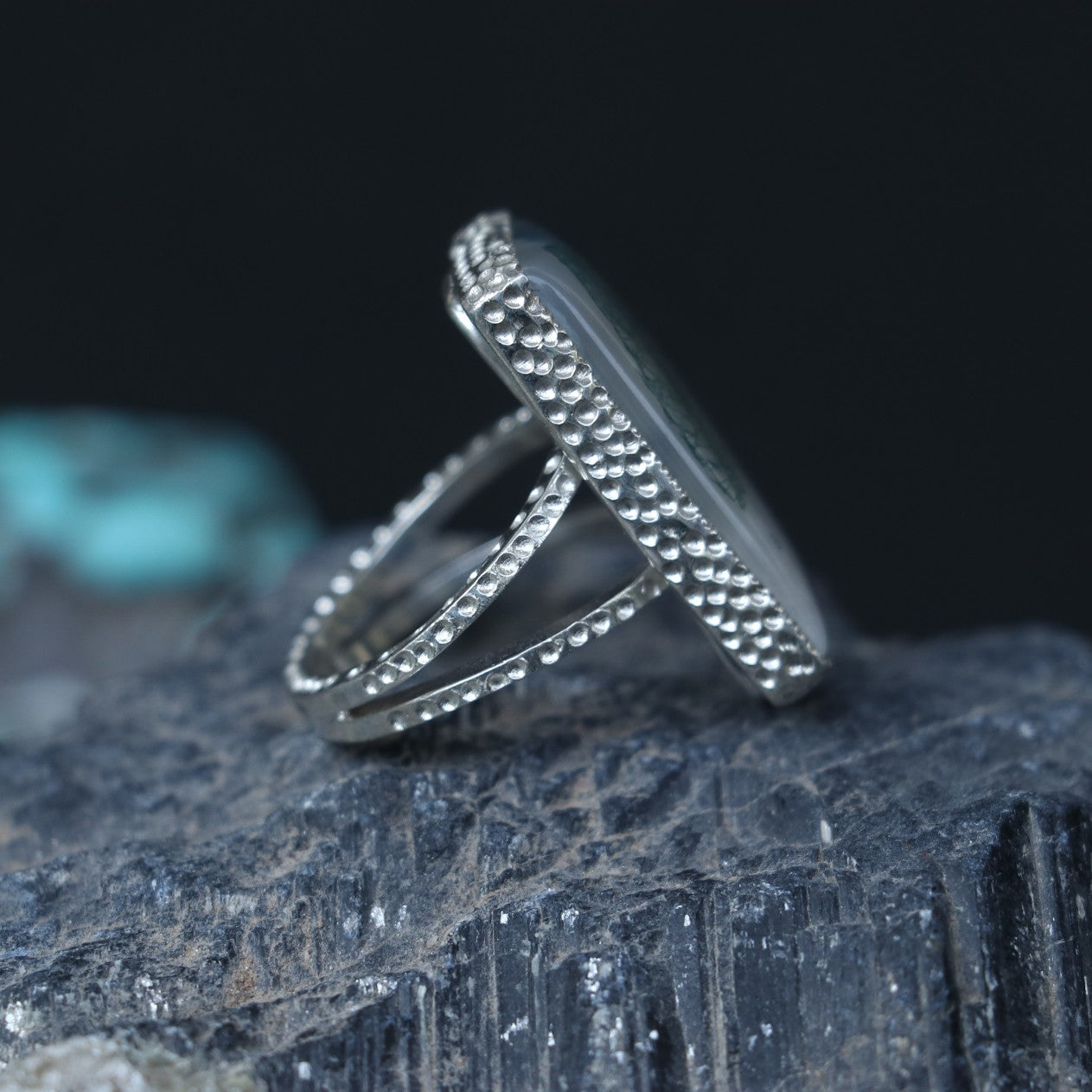 SILVER RING SHOWCASING A LARGE RECTANGULAR MOSS AGATE STONE