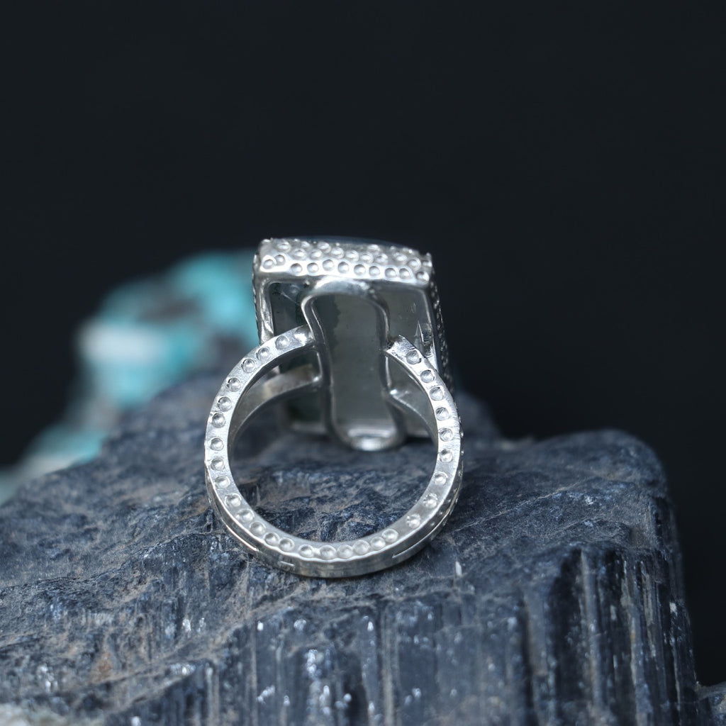 SILVER RING SHOWCASING A LARGE RECTANGULAR MOSS AGATE STONE