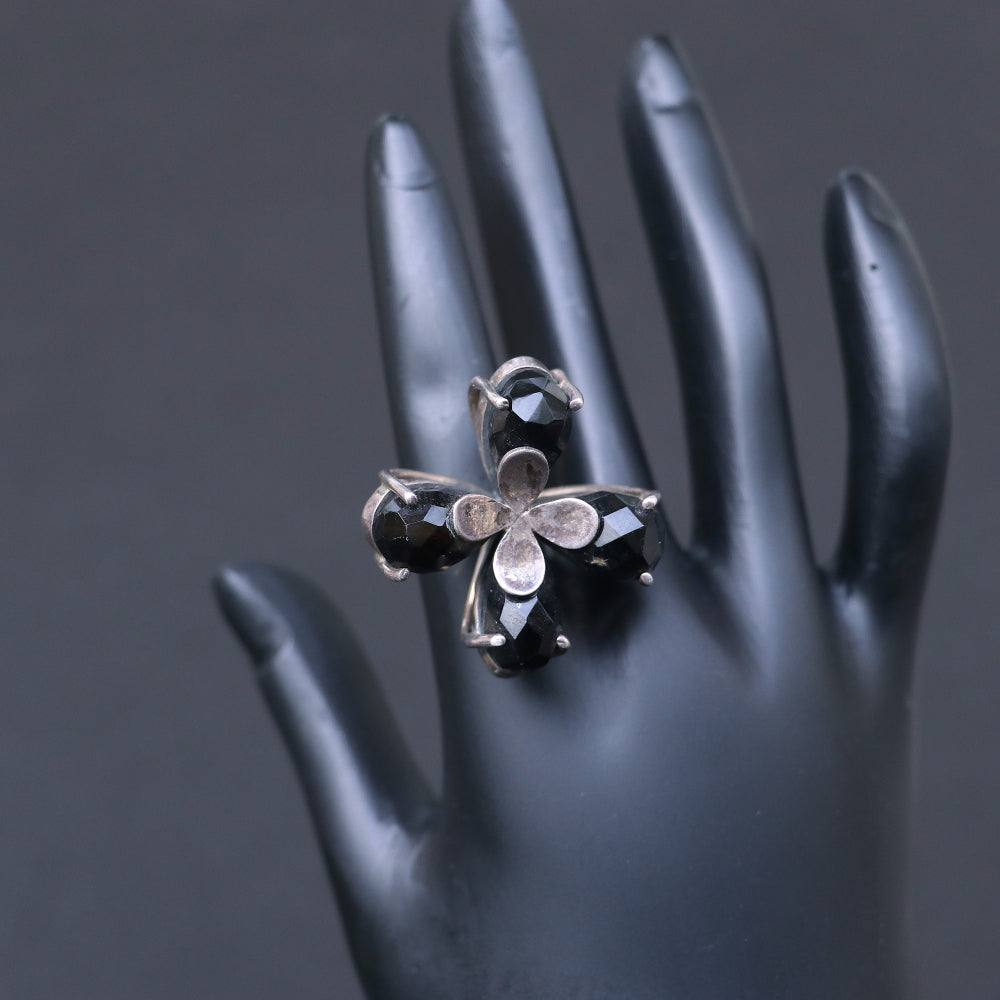 Silver ring featuring smoky topaz stones elegantly arranged in a floral pattern.