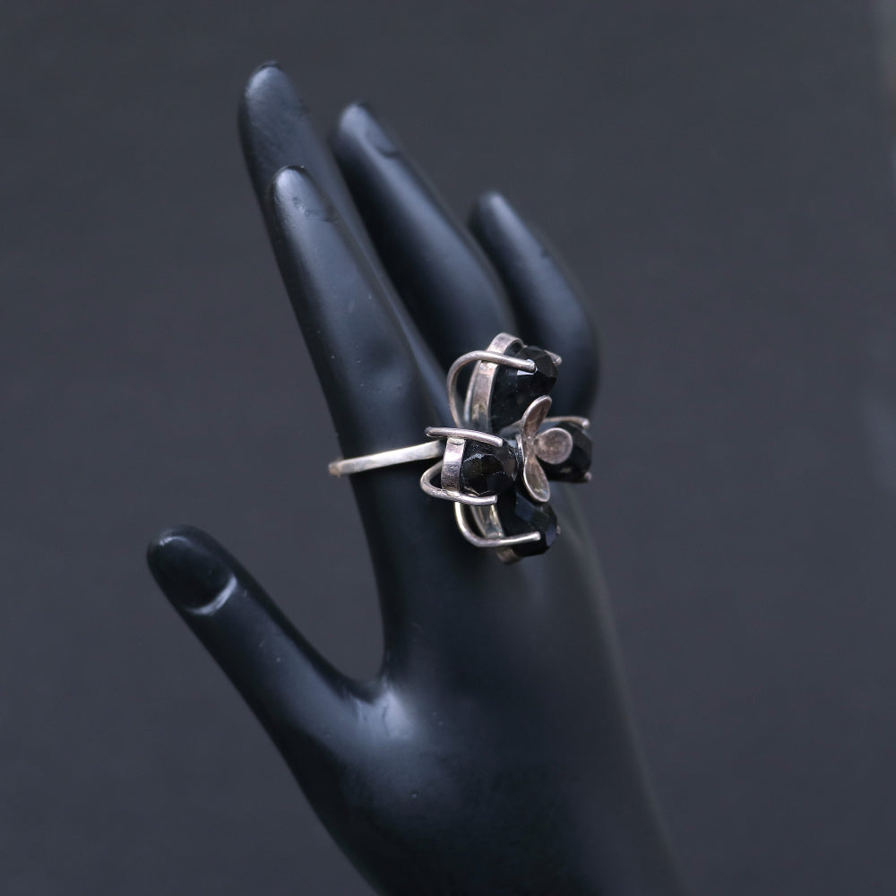 Silver ring featuring smoky topaz stones elegantly arranged in a floral pattern.