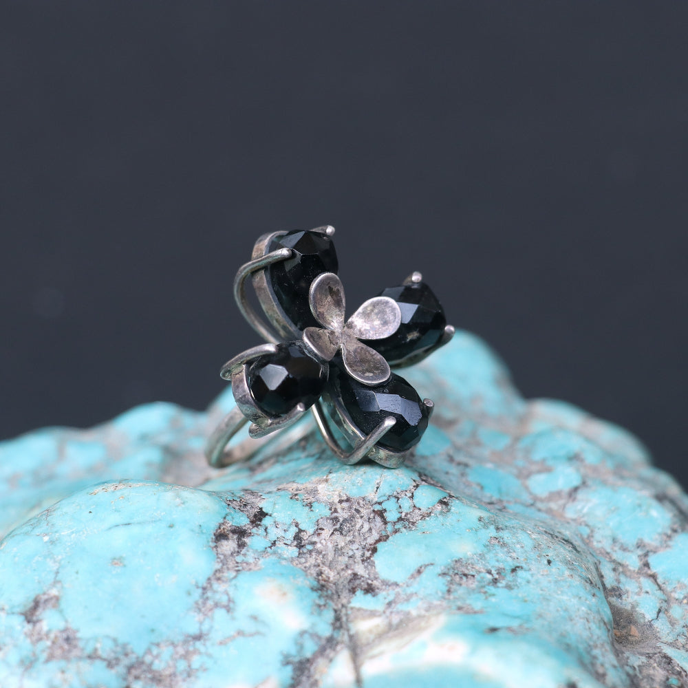 Silver ring featuring smoky topaz stones elegantly arranged in a floral pattern.