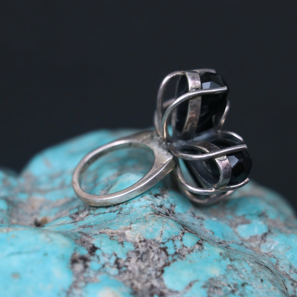 Silver ring featuring smoky topaz stones elegantly arranged in a floral pattern.