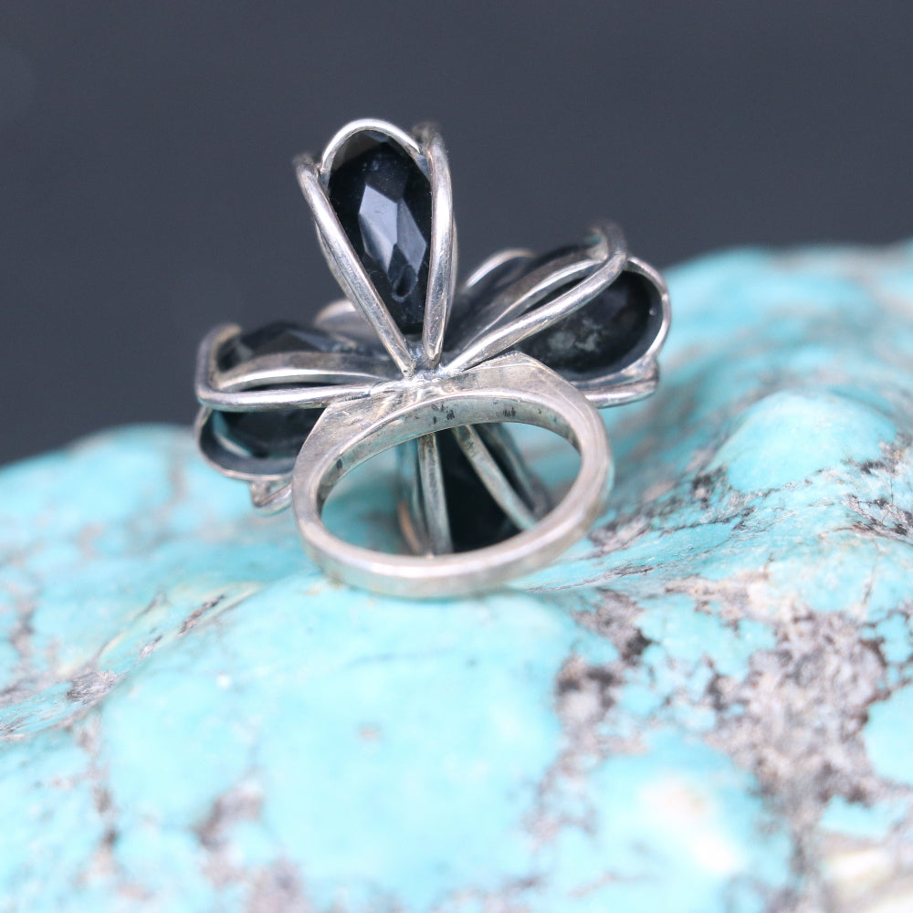 Silver ring featuring smoky topaz stones elegantly arranged in a floral pattern.