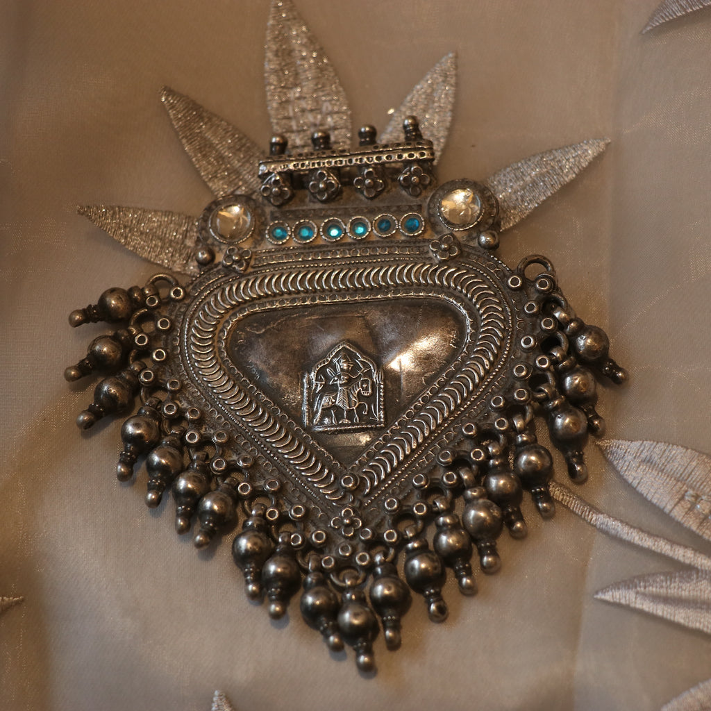 SILVER PENDANT WITH TRIBAL MOTIF , BLUE ACCENTS , AND HANGING BEEDS